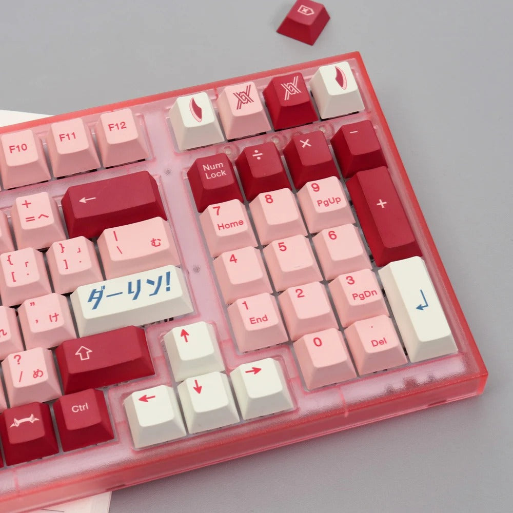 A close-up image of the Darling Keycap Set, showcasing the pink and red keycaps with celestial-inspired designs. The image also includes a partial view of the mechanical keyboard itself.