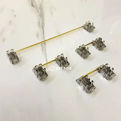 A set of transparent plastic stabilizers with gold wire, arranged in various sizes and configurations on a white background. The image includes the brand name "Keybox."